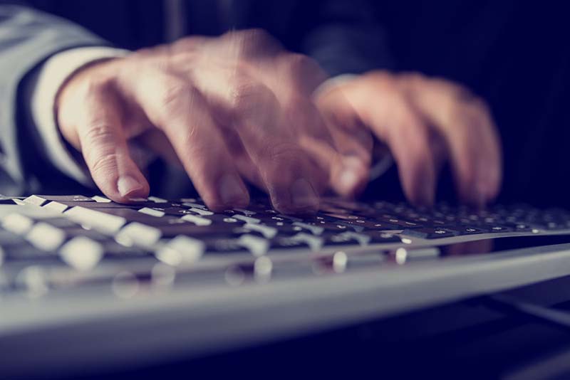 Fingers typing on a keyboard.